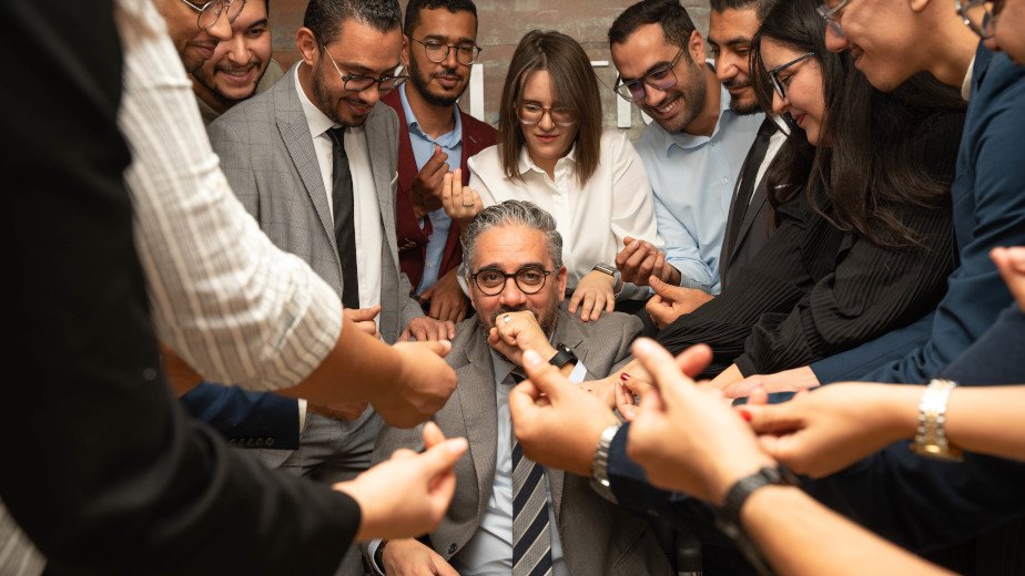 Une équipe soudée, réunie autour de son manager, partageant un moment complice et plein d’humour… avec une petite demande d’argent en prime !